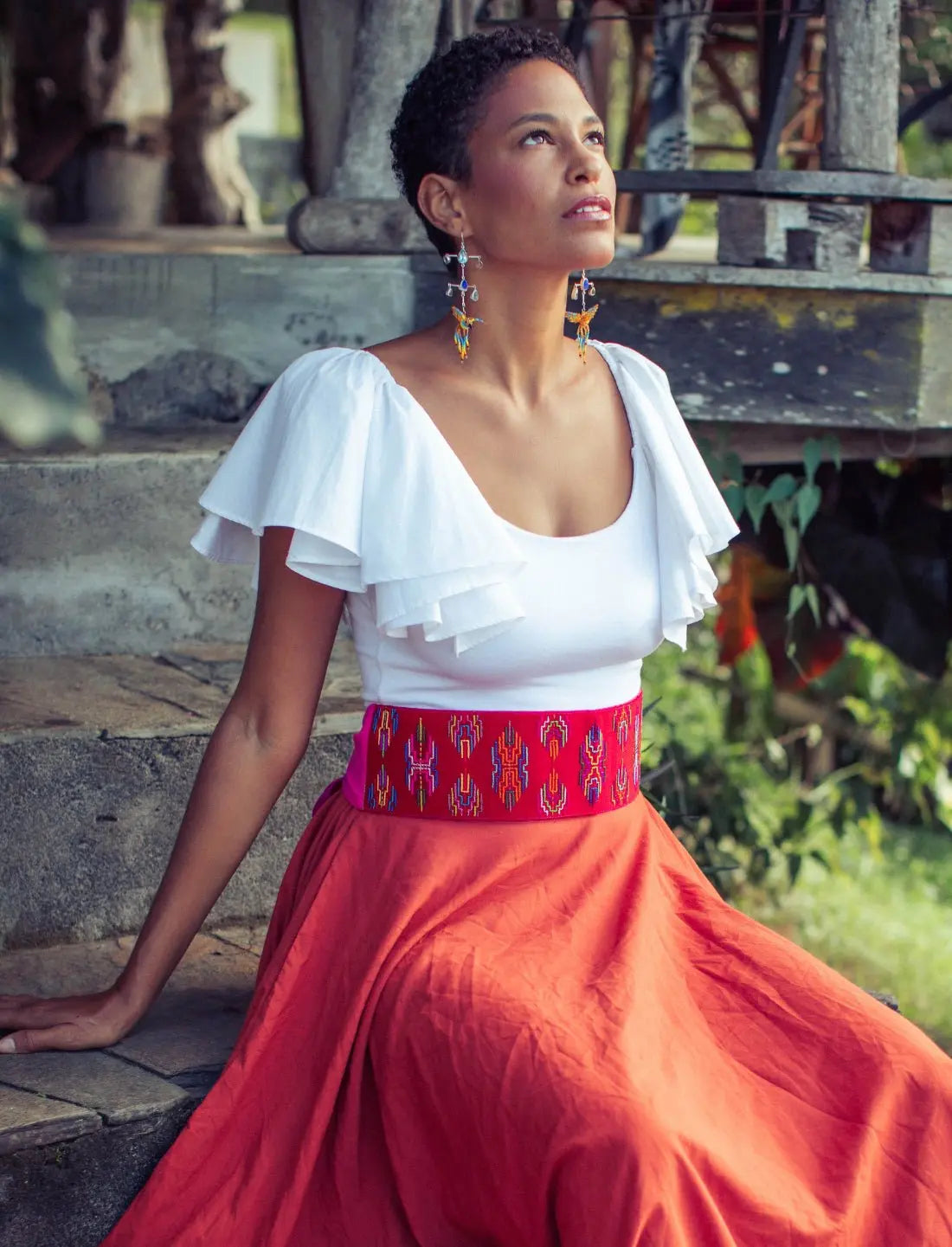 Timar Varja Vibration Red Multicolored Belt with a Terracotta Sacred Hoop of Life Skirt and White Ina Bodysuit. A complete Earth Wisdom Collection look that is elegant and intriguing.